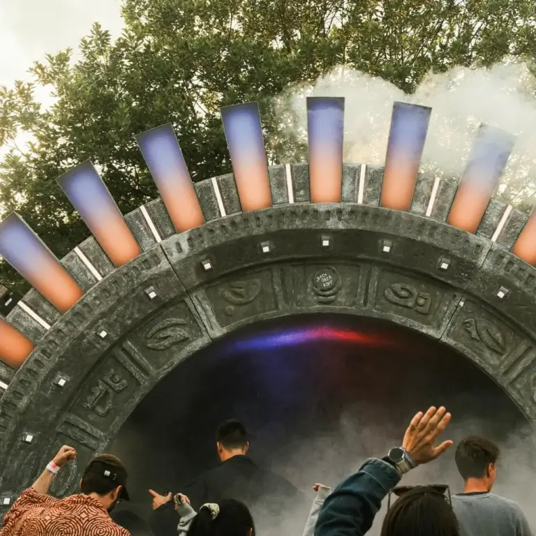 Close-up des beleuchteten Sonnentor-Bühnenbogens des DachüberKopf Festivals mit dramatischem Bühnennebel, farbigen LED-Elementen und jubelndem Publikum